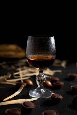 şarap, çikolata ve meyve karanlık bir arka plan üzerinde gözlük