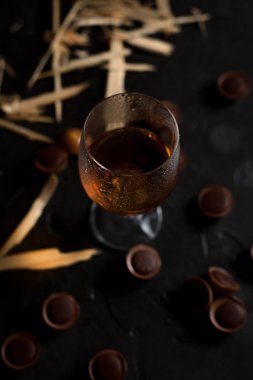 şarap, çikolata ve meyve karanlık bir arka plan üzerinde gözlük
