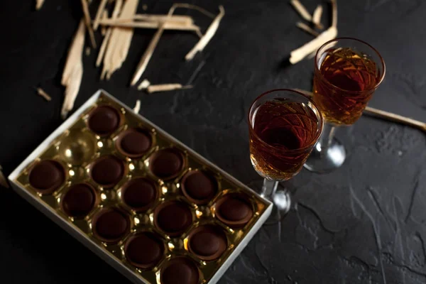 şarap, çikolata ve meyve karanlık bir arka plan üzerinde gözlük