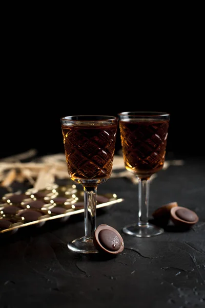 Стаканы с вином, шоколадом и фруктами на темном фоне — стоковое фото