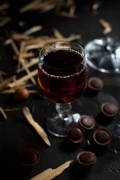 Стаканы с вином, шоколадом и фруктами на темном фоне — стоковое фото