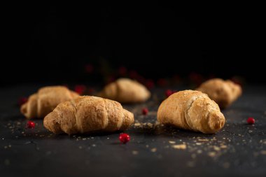 kırıntıları ve karanlık bir arka plan üzerinde kırmızı meyveler ile birkaç tüm ay çöreği