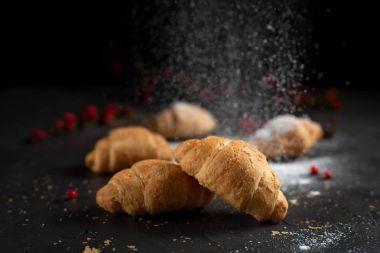 kırıntıları ve karanlık bir arka plan üzerinde kırmızı meyveler ile birkaç tüm ay çöreği