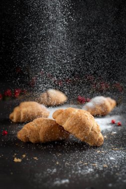 kırıntıları ve karanlık bir arka plan üzerinde kırmızı meyveler ile birkaç tüm ay çöreği