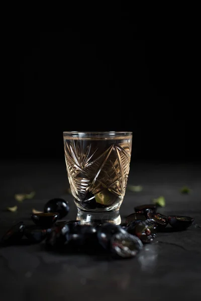 Szkło przezroczyste drinkiem i winogron segmentów na ciemnym tle — Zdjęcie stockowe