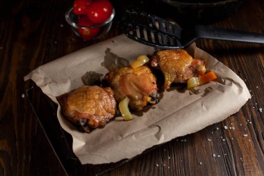 bir gevrek kabuk, baharatlar, pişirme kağıdı, büyük deniz tuzu koyu ahşap zemin üzerinde siyah bir plaka üzerinde sulu tavuk pişmiş