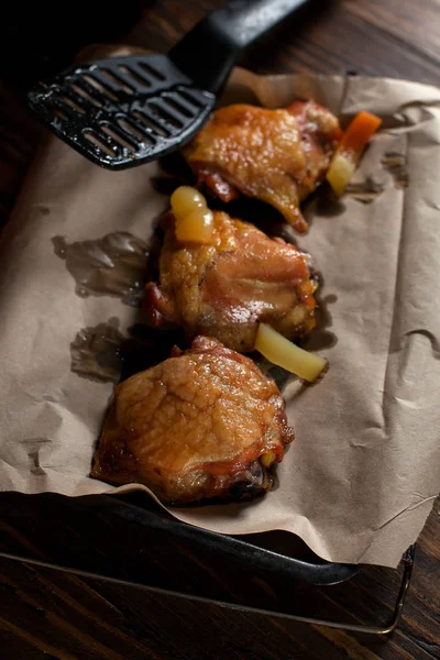 Ζουμερό Κοτόπουλο φούρνου με μια τραγανή κρούστα, με μπαχαρικά, σε μαύρη πλάκα, σε αντικολλητικό χαρτί, μεγάλο θαλασσινό αλάτι σε σκούρο φόντο ξύλινη — Φωτογραφία Αρχείου