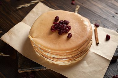 bir yığın krep, çilek, tanımlama bilgileri, ekşi krema ve koyu ahşap bir masa şurubu