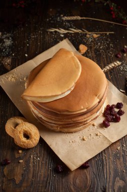 yığın krep katlanmış, gözleme, çilek, Çerezler, pudra şekeri, koyu ahşap masa üzerinde parşömen üzerine karamel şurup