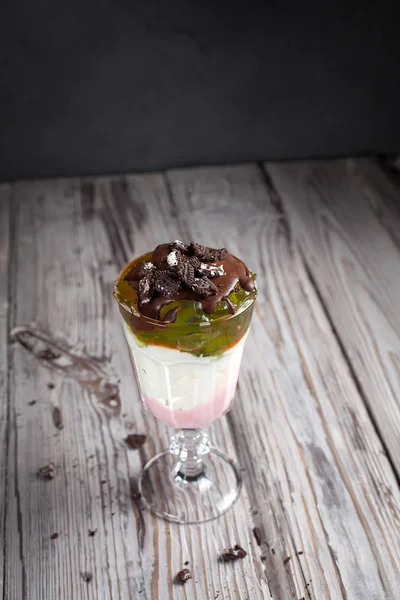 Dessert avec gelée, chocolat et baies sur fond de bois gris — Photo