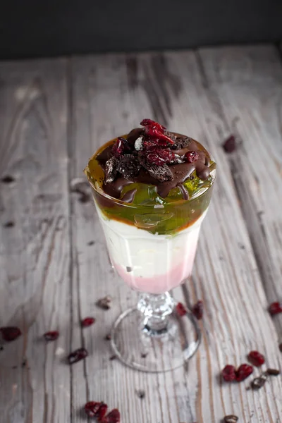 Dessert avec gelée, chocolat et baies sur fond de bois gris — Photo