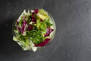 taze vejetaryen Detoks karanlık bir arka plan üzerinde Zeytinyağlı yeşil salata