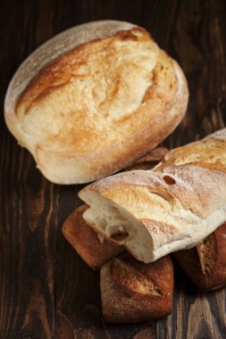 karanlık bir arka plan üzerinde ahşap bir masa üzerinde taze pişmiş ekmek