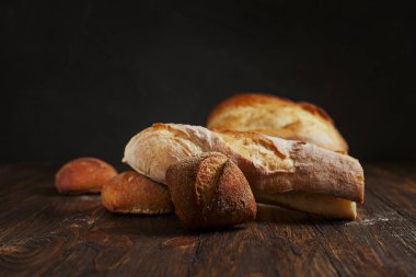 karanlık bir arka plan üzerinde ahşap bir masa üzerinde taze pişmiş ekmek