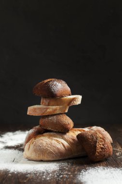 karanlık bir arka plan üzerinde ahşap bir masa üzerinde taze pişmiş ekmek