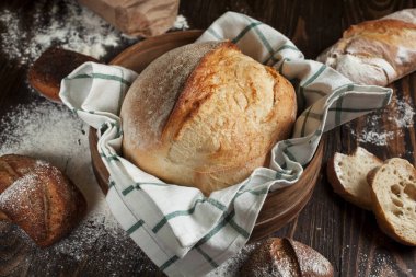 karanlık bir arka plan üzerinde ahşap bir masa üzerinde taze pişmiş ekmek
