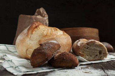 karanlık bir arka plan üzerinde ahşap bir masa üzerinde taze pişmiş ekmek