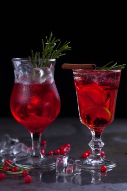 kireç, kırmızı meyveler, biberiye ve buz küpleri biberiye karanlık bir arka plan üzerinde bir arka plan üzerinde kırmızı renk bir kokteyl ile bir bardak