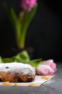 taze pişmiş kek tatlılar, Kuru üzüm ve şekerlenmiş meyve, Pembe Lale ile gri bir tabloda pudra şekeri serpilir