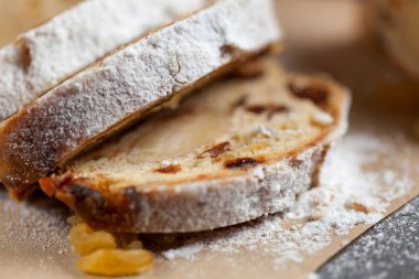 taze pişmiş kek tatlılar, Kuru üzüm ve şekerlenmiş meyve, gri bir tablo üzerine pudra şekeri serpilir