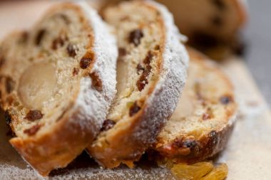 taze pişmiş kek tatlılar, Kuru üzüm ve şekerlenmiş meyve, gri bir tablo üzerine pudra şekeri serpilir