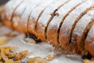taze pişmiş kek tatlılar, Kuru üzüm ve şekerlenmiş meyve, gri bir tablo üzerine pudra şekeri serpilir