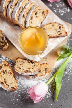 Tatlılar, Kuru üzüm ve pudra şekeri ile serpilir şekerlenmiş meyve ile kek fırından yeni çıkmış sıcak bir içecek ile elma üzerinde gri bir masa ile pembe laleler