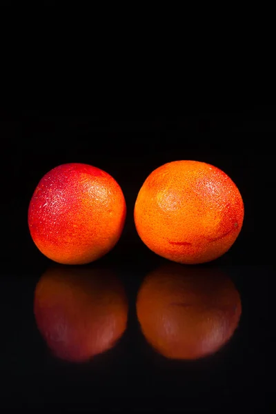 two oranges on black wooden table