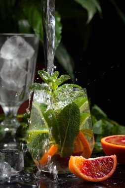 karanlık bir arka plan üzerine bir bardak limonata. sprey ve hareket