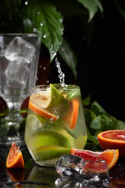 karanlık bir arka plan üzerine bir bardak limonata. sprey ve hareket