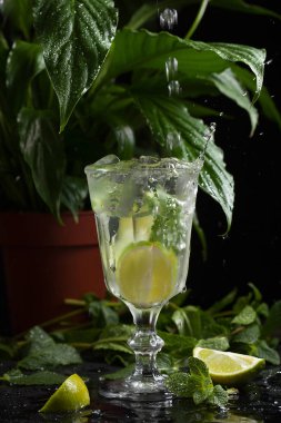 karanlık bir arka plan üzerine bir bardak limonata. sprey ve hareket