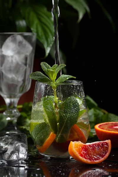 karanlık bir arka plan üzerine bir bardak limonata. sprey ve hareket