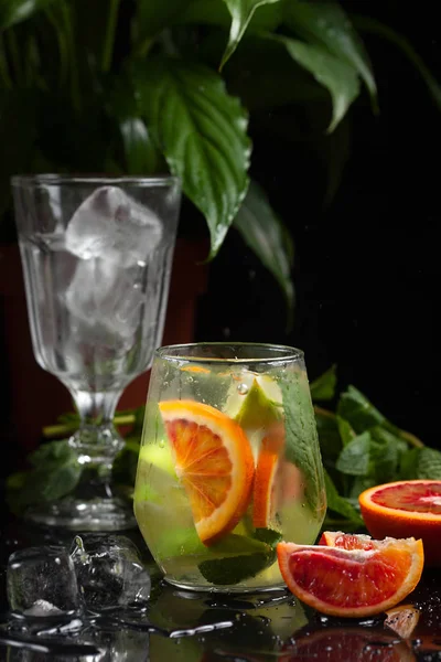 Lemonade in a glass on a dark background. spray and motion — Stock Photo, Image