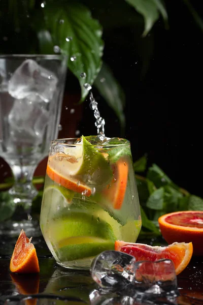 karanlık bir arka plan üzerine bir bardak limonata. sprey ve hareket