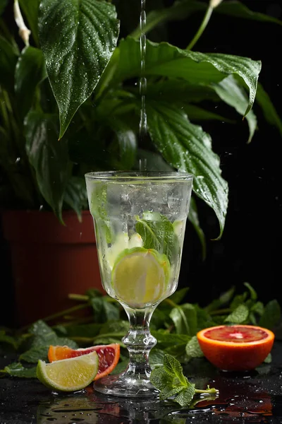 karanlık bir arka plan üzerine bir bardak limonata. sprey ve hareket