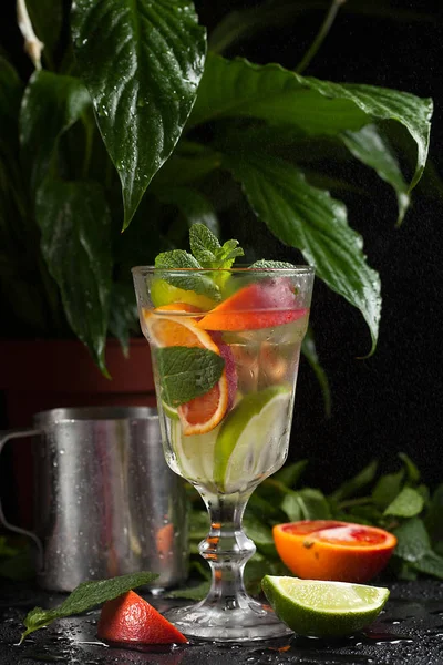 Λεμονάδα σε ένα ποτήρι σε σκούρο φόντο. σπρέι και κίνηση — Φωτογραφία Αρχείου