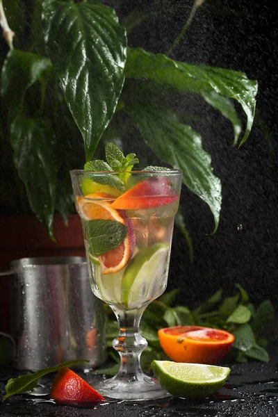 Lemonade in a glass on a dark background. spray and motion — Stock Photo, Image