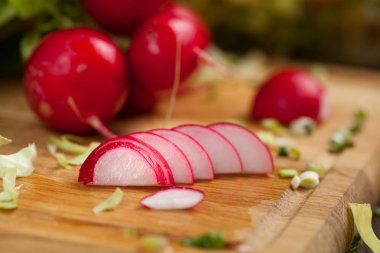 Eski koyu ahşap arka plan üzerinde seçici odak ışını ile taze kırmızı turp yaprakları