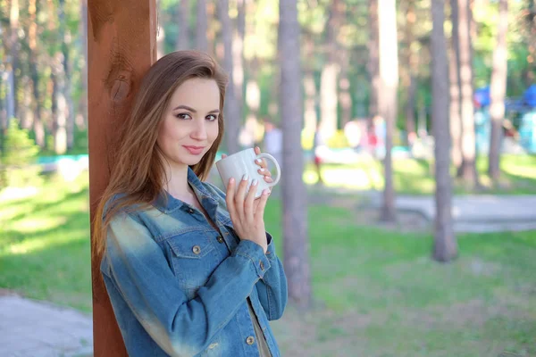 Primer plano retrato de una chica sonriente en sombrero sosteniendo llevar taza de café al aire libre — Foto de Stock