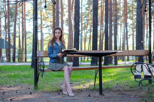 Joven hermosa chica leyendo un libro al aire libre — Foto de Stock