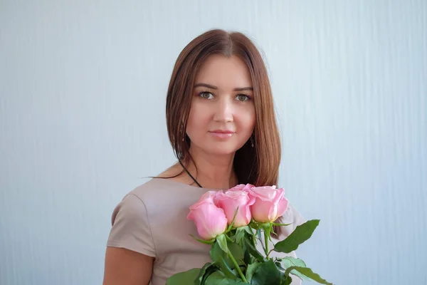 장미 꽃다발을 들고 있는 아름다운 젊은 여자 — 스톡 사진