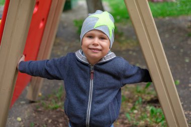 Küçük çocuk parkta oynarken parlak yaz gününde