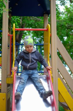 Küçük çocuk parkta oynarken parlak yaz gününde