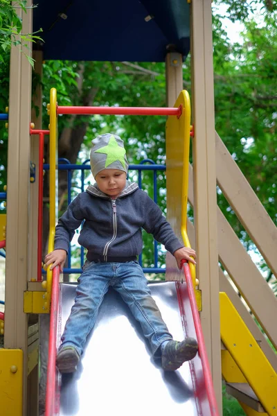 Küçük çocuk parkta oynarken parlak yaz gününde