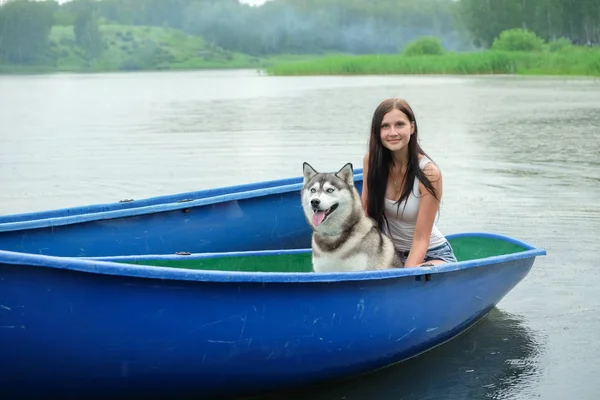Piękna dziewczyna i Husky pies w łodzi. — Zdjęcie stockowe