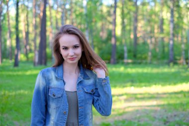 Bir parkta mükemmel gülümsemeyle gülümseyerek ve kameraya arayan kadın