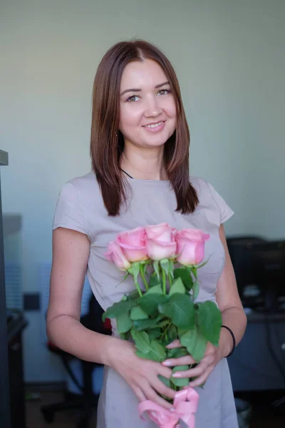 Menina bonita foi presenteado com um buquê de rosas — Fotografia de Stock