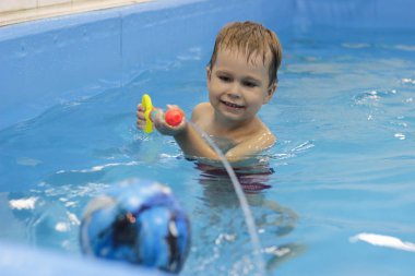 Küçük çocuk havuzunda su tabancası ile çekim