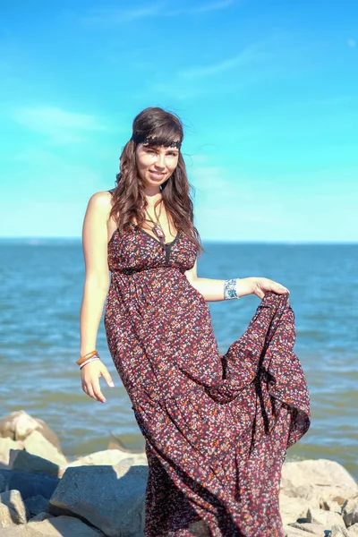 Bela jovem mulher de pé na pedra na praia — Fotografia de Stock