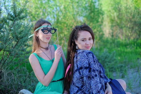 Deux jeunes femmes assises sur l'herbe passer du bon temps — Photo